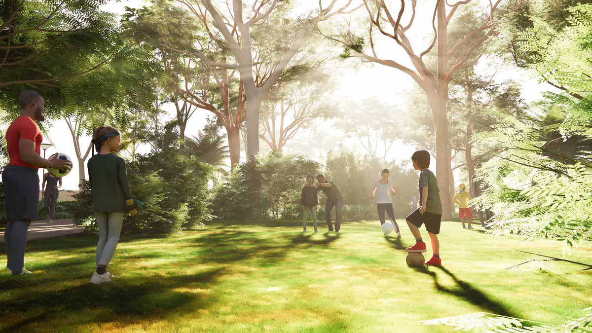 Children playing football on an open lawn under tall trees